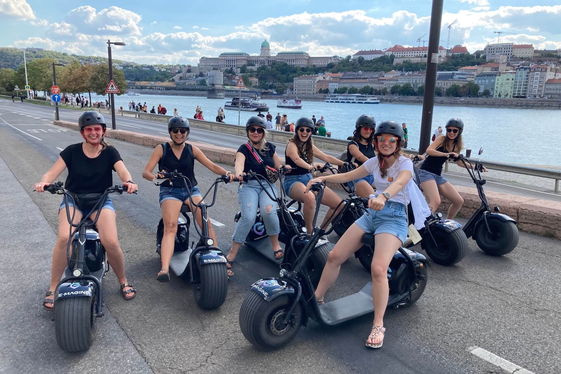 Damas en E-Scooters en el lado de Pest del Danubio