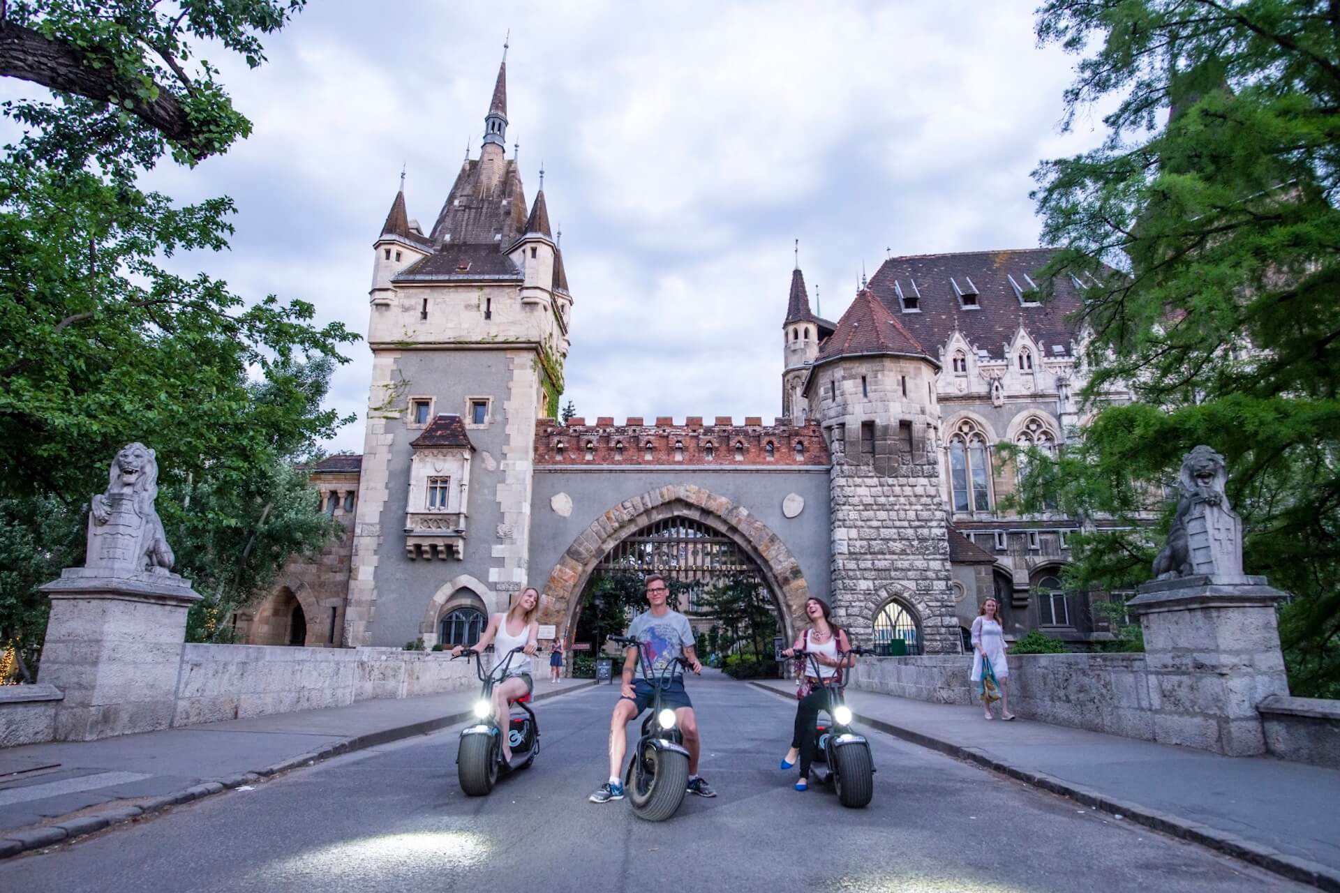 People riding MonsteRollers in front of the entrance of Vajdahunyad Castle