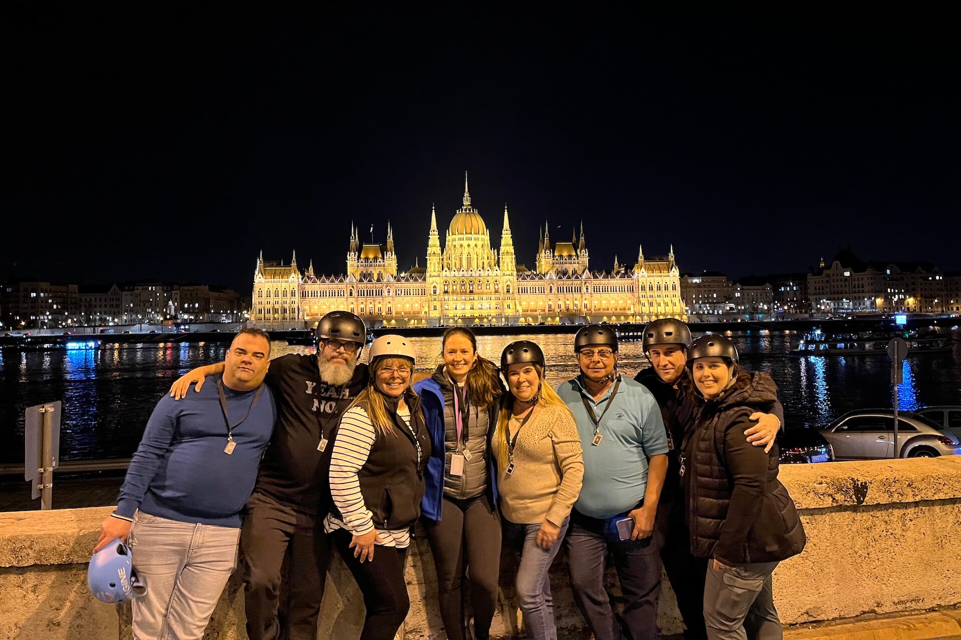 A group of people on the Night Tour with the Parliament in the background