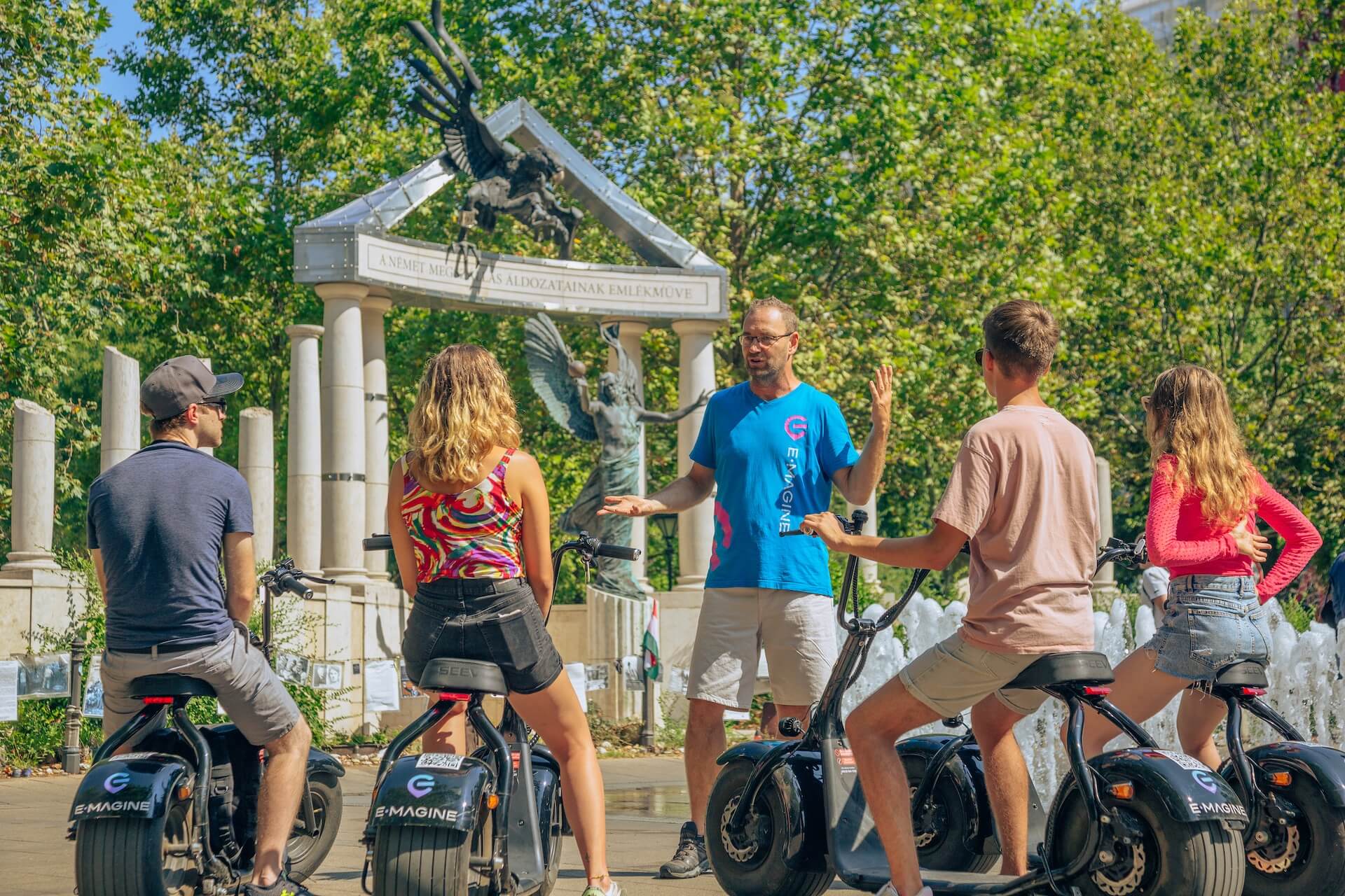 Young people listening to their guide while on a Private E-Scooter Tour
