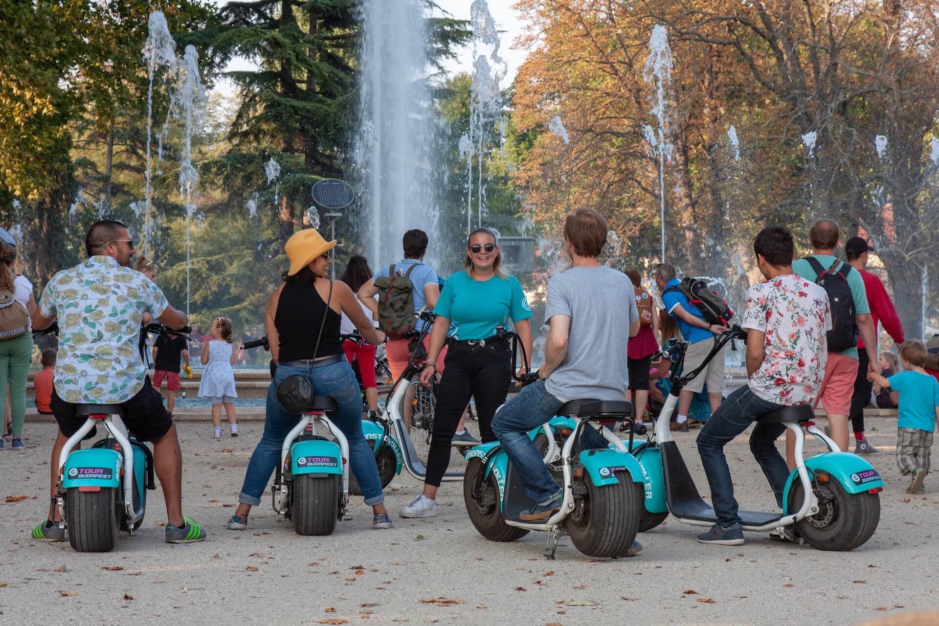 Des gens sur des e-scooters devant la fontaine musicale de Margaret Island