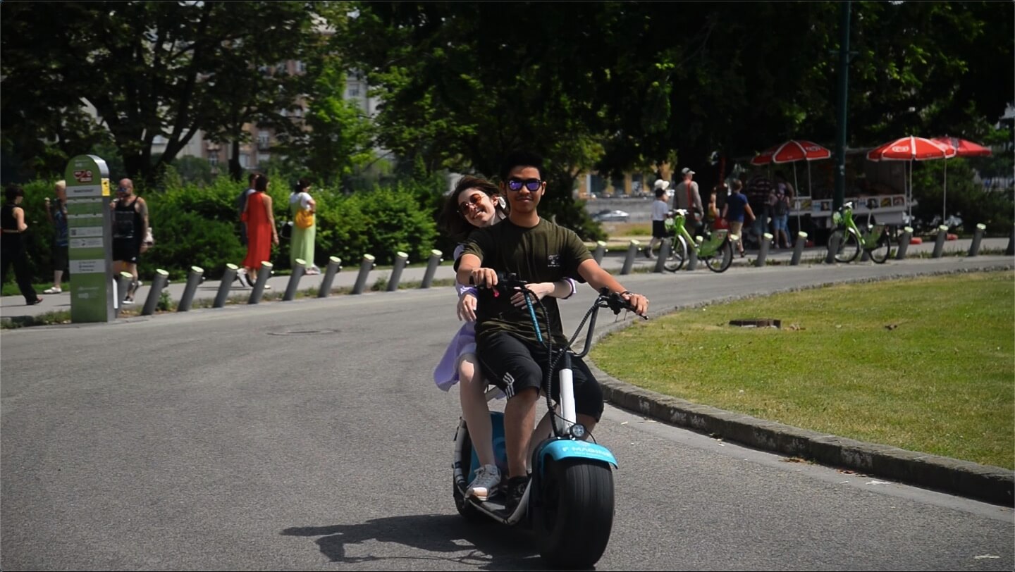 Un couple monté sur un gros pneu escooter sur Margaret Island