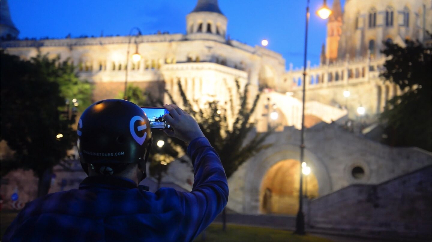 Hombre tomando una foto de la entrada del Castillo de Buda y el Bastión de los Pescadores