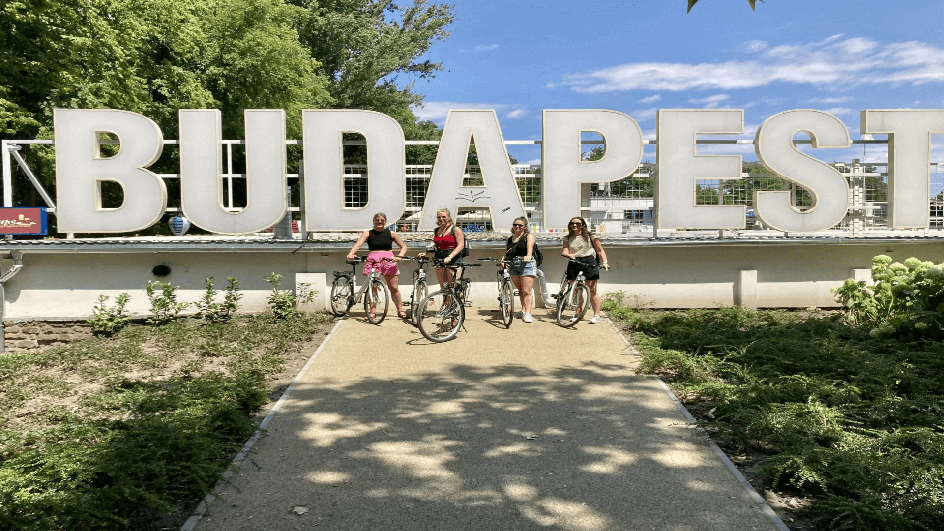 4 people standing in front of a Budapest sign